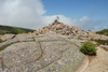 Large rock cairn atop Dorr Mountain in Acadia National Park, marking the summit against a backdrop of rugged granite and open sky.