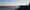 Sunrise over the Atlantic Ocean along Acadia National Park’s Ocean Path, with rocky cliffs and evergreen trees lining the shore.